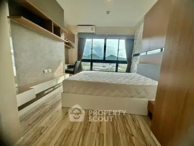 Modern bedroom with stunning mountain view and sleek wooden flooring.