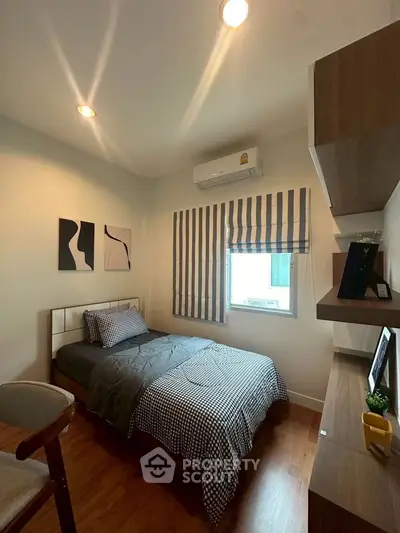 Cozy bedroom with modern decor and natural light, perfect for relaxation.