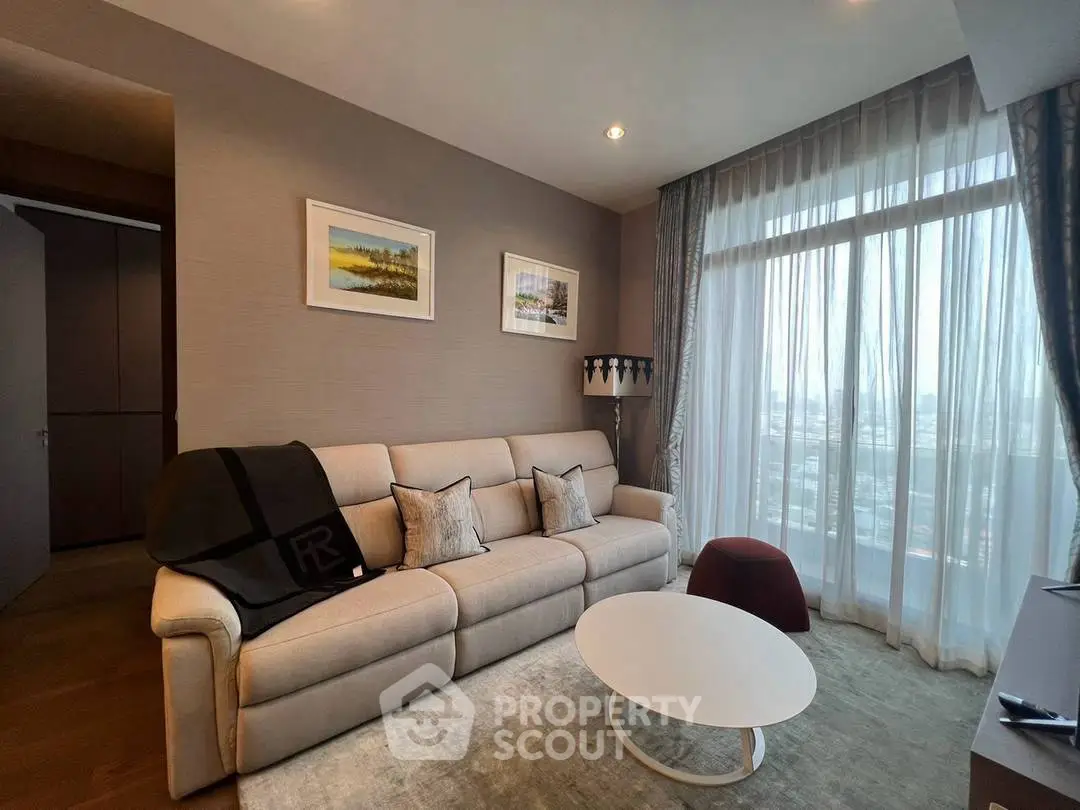 Elegant living room with large window and modern decor in a high-rise apartment.