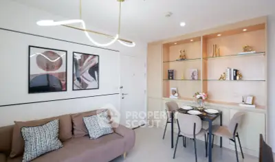 Modern living room with stylish decor and dining area, featuring elegant lighting and wall art.