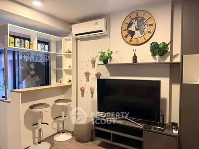 Modern living room with stylish decor, wall clock, and bar seating in a cozy apartment.
