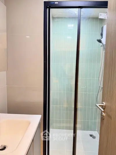Modern bathroom with sleek shower and stylish sink in contemporary apartment.