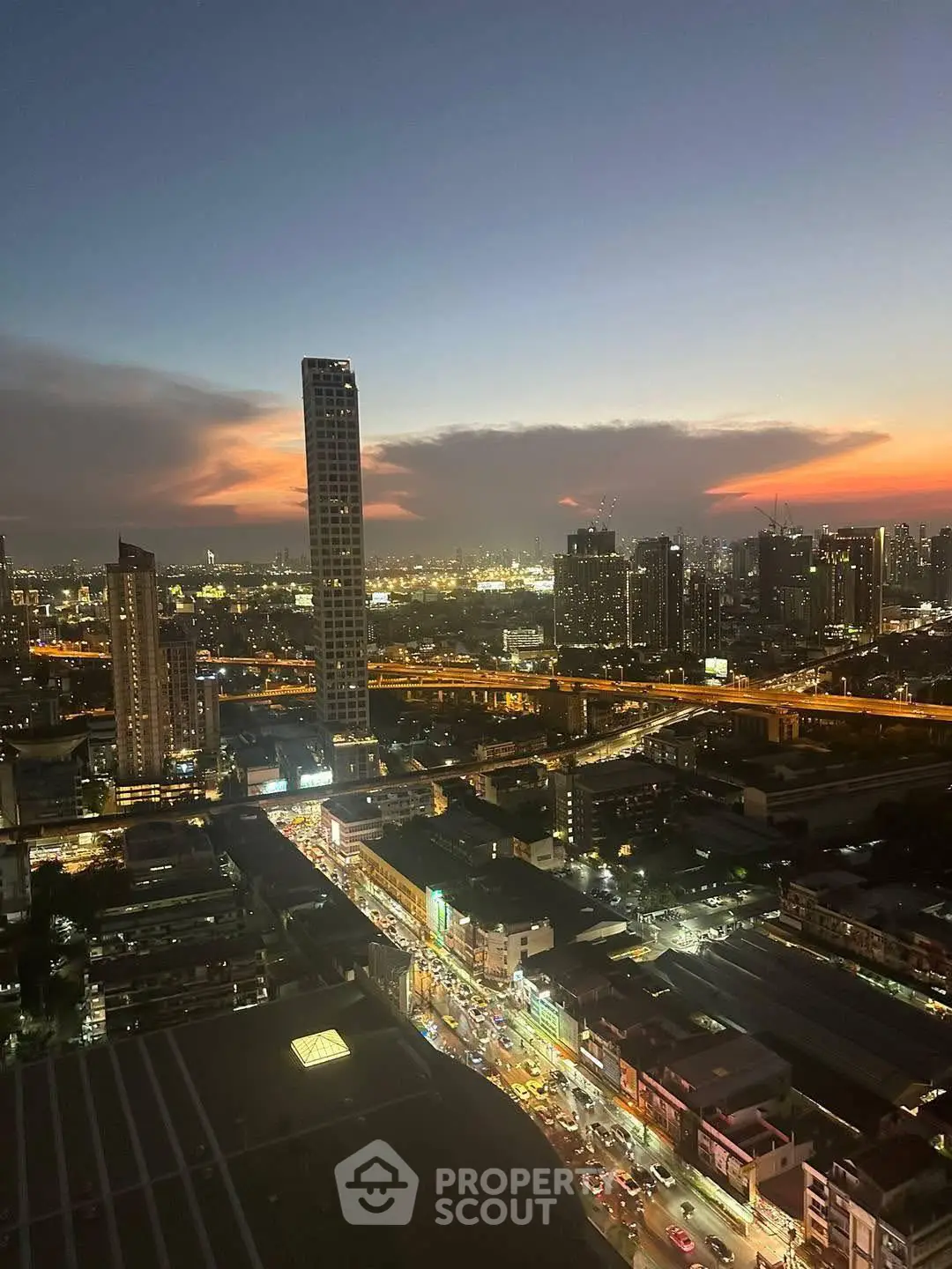 Stunning cityscape view from high-rise building at sunset, showcasing vibrant urban skyline.