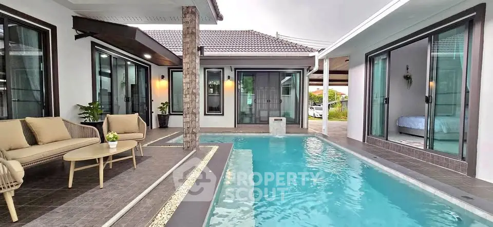 Luxurious modern home with private pool and stylish outdoor seating area.