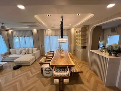 Luxurious open-plan living and dining area with elegant wood finishes and modern lighting.