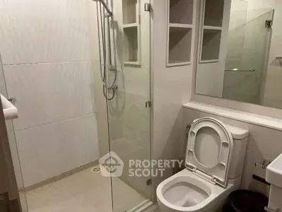 Modern bathroom with glass shower and sleek toilet design.