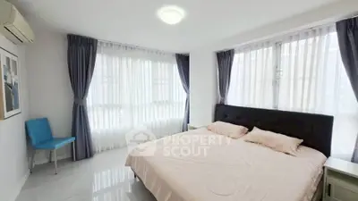 Spacious bedroom with large windows and elegant curtains in modern apartment