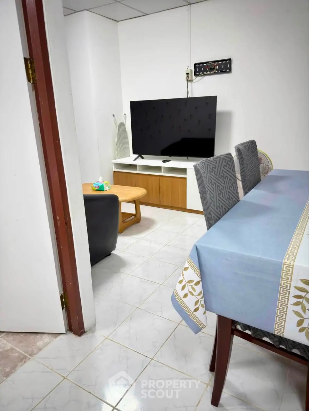 Cozy living room with modern TV setup and dining area, perfect for family gatherings.