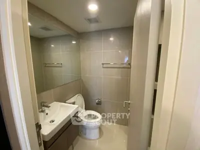 Modern bathroom with sleek fixtures and neutral tiles, perfect for a contemporary home.