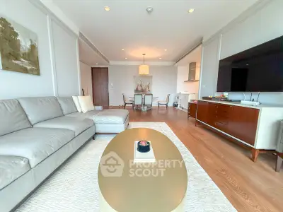 Spacious modern living room with elegant decor and open layout, featuring a large sofa and stylish furniture.