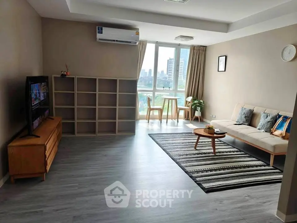 Spacious modern living room with city view, stylish furniture, and natural light.