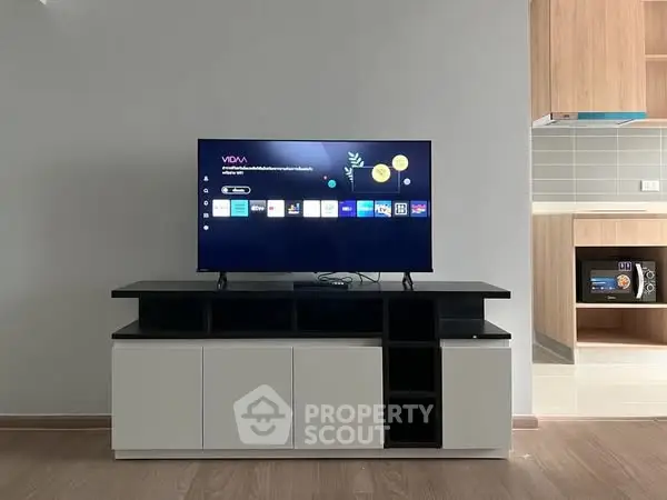 Modern living room with sleek TV stand and open kitchen view
