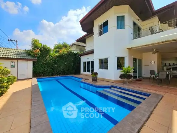 Stunning two-story home with private pool and spacious patio in lush garden setting.