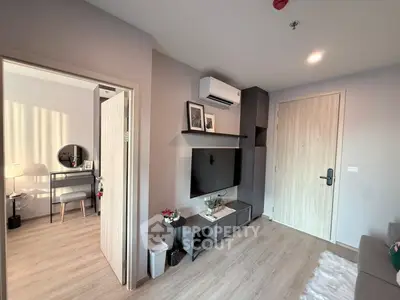 Modern living room with TV and air conditioning, featuring stylish decor and wooden flooring.