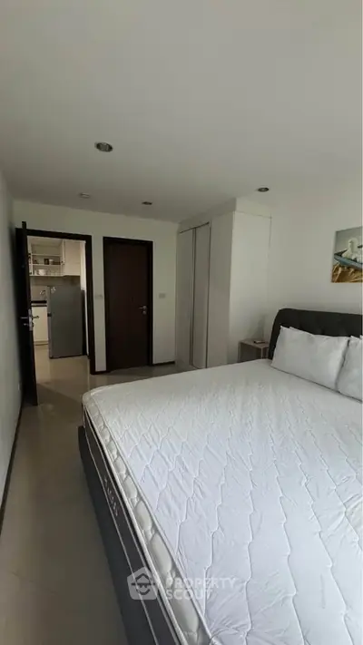 Spacious bedroom with modern design and ample natural light, featuring a comfortable bed and sleek wardrobe.