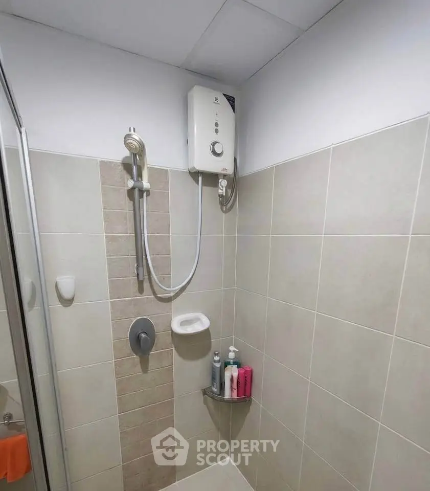 Modern bathroom shower area with water heater and tiled walls