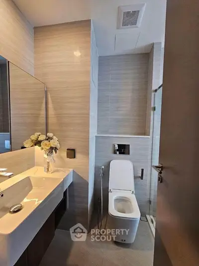 Modern bathroom with sleek fixtures and elegant design, featuring a stylish sink and toilet.