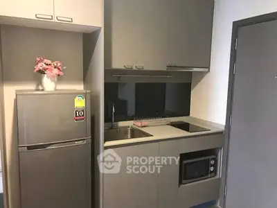 Modern compact kitchen with sleek cabinetry and built-in appliances in a stylish apartment.