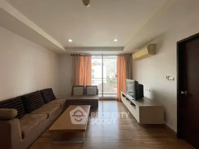 Spacious living room with modern decor and large window offering city views.