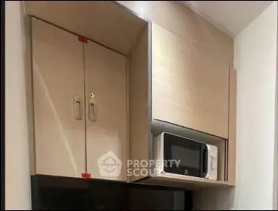 Modern kitchen with sleek cabinets and built-in microwave for efficient storage.