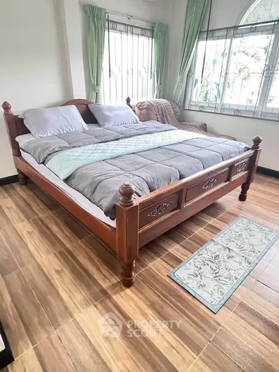 Spacious bedroom with elegant wooden bed and large windows for natural light.