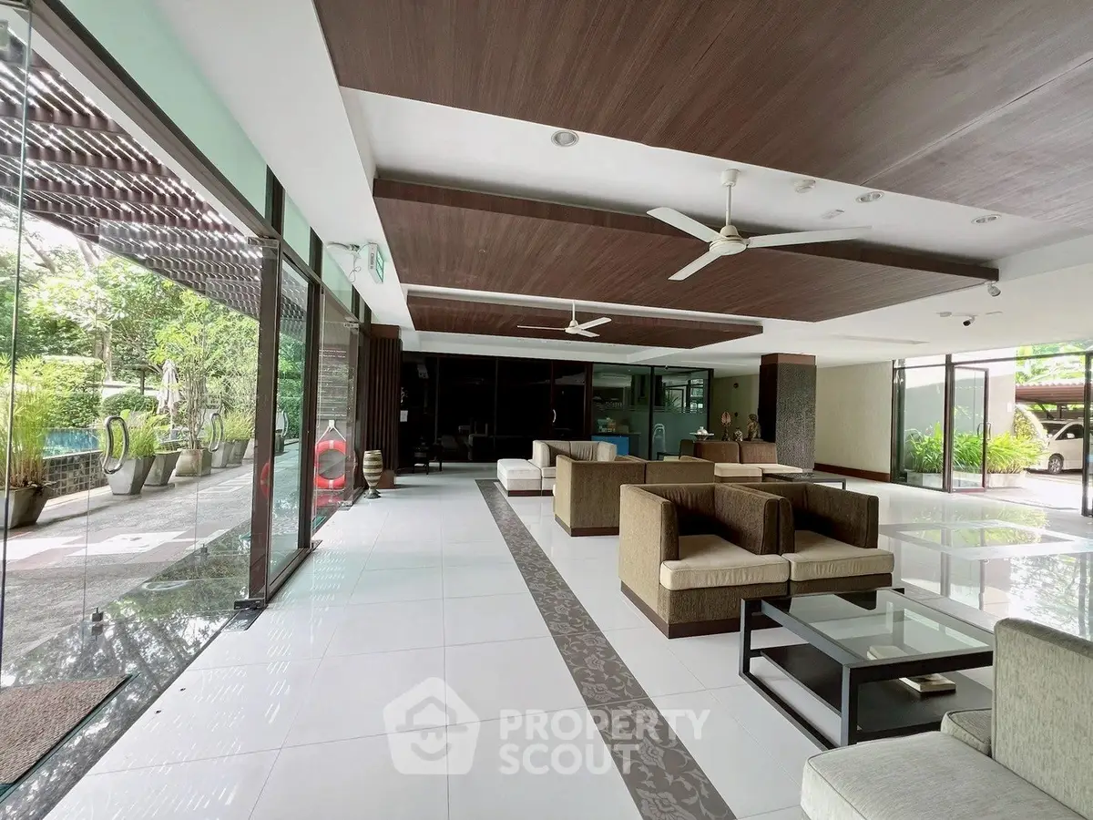 Spacious modern lobby with elegant seating and lush garden view, perfect for welcoming guests.
