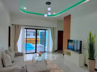 Modern living room with pool view, featuring elegant decor and spacious layout.