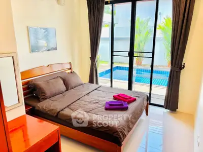 Cozy bedroom with pool view, featuring elegant wooden furniture and large windows for natural light.