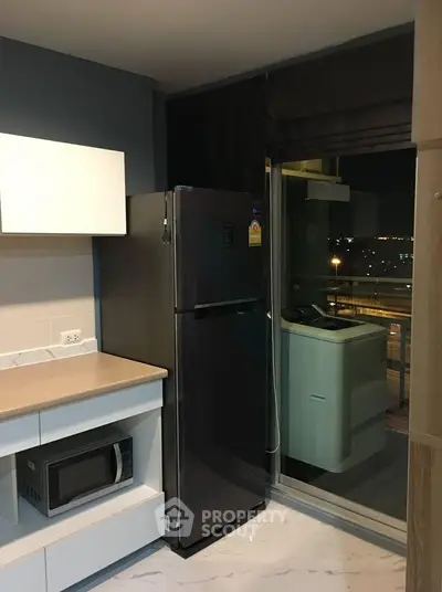 Modern kitchen with sleek appliances and balcony view in urban apartment