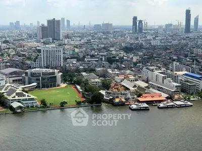 Stunning aerial view of urban skyline with riverfront and high-rise buildings, showcasing vibrant city life.