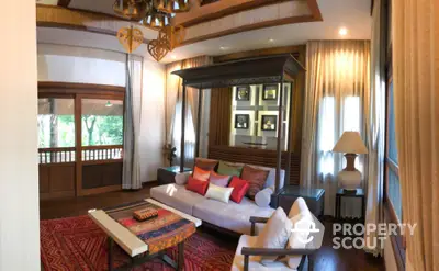 Luxurious living room with traditional wooden four-poster bed, elegant furnishings, and vibrant red carpet, offering a blend of comfort and style.