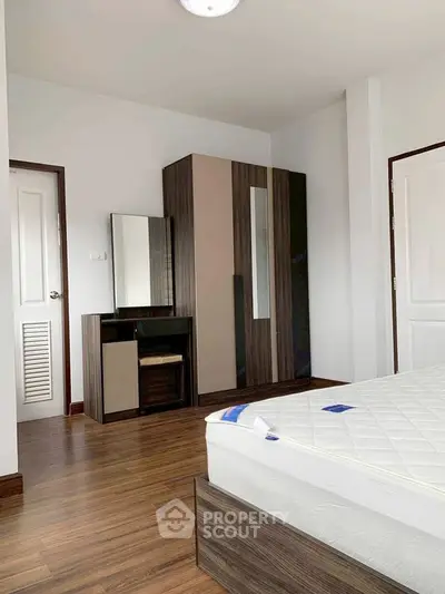 Spacious bedroom with modern furniture and wooden flooring