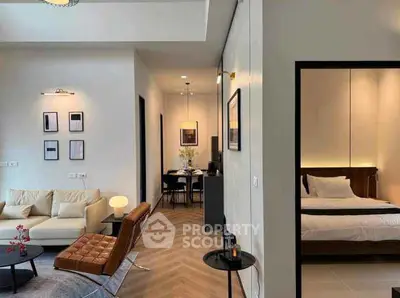 Modern open layout living room with stylish furniture and adjacent bedroom