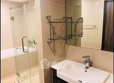 Modern bathroom with glass shower and sleek fixtures in contemporary home.