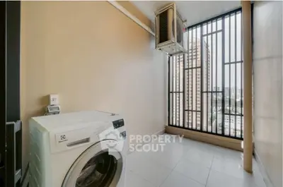 Modern laundry area with washing machine and city view from balcony.