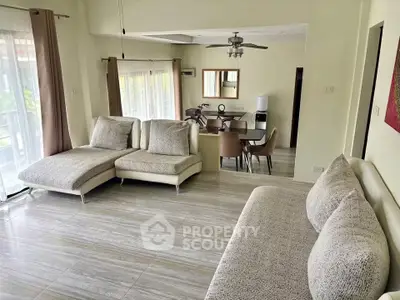 Spacious living room with modern furniture and dining area, featuring large windows and elegant decor.