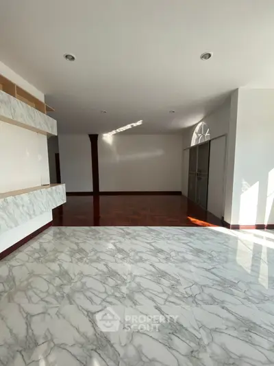 Spacious interior with elegant marble flooring and ample natural light.