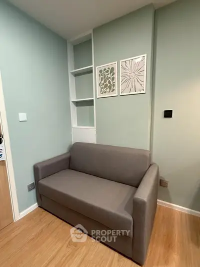 Cozy living room corner with modern gray sofa and stylish wall art