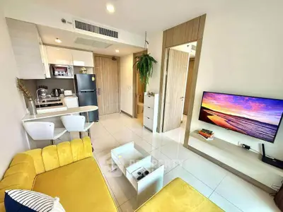 Modern living room with vibrant yellow sofa and sleek kitchen area