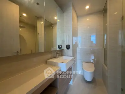 Modern bathroom with sleek fixtures and elegant design, featuring a spacious vanity and contemporary toilet.