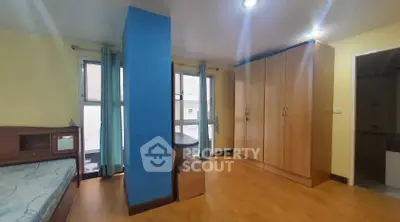 Spacious bedroom with wooden flooring and ample natural light