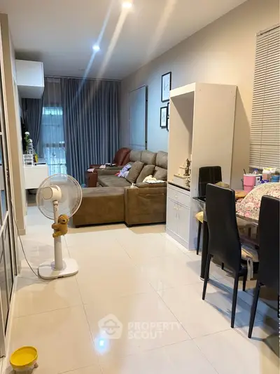 Spacious living room with modern furniture and dining area in a cozy apartment.
