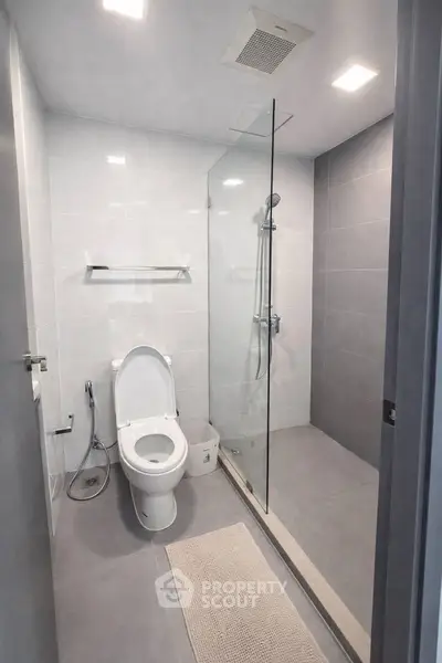 Modern bathroom with glass shower and sleek design in contemporary apartment.