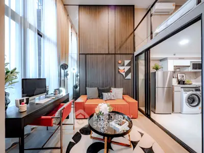 Modern living room with high ceilings and stylish decor adjacent to a sleek kitchen area.