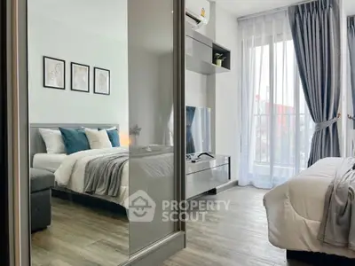 Modern bedroom with stylish decor and large window offering natural light.