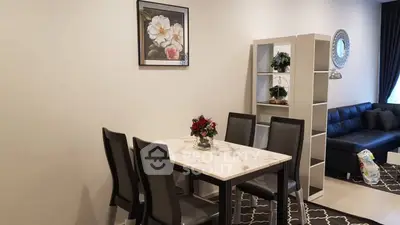 Modern dining area with elegant marble table and stylish black chairs in a cozy living room setting.