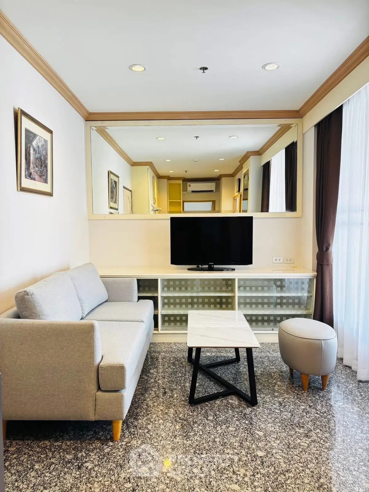 Modern living room with stylish furniture and large mirror enhancing space