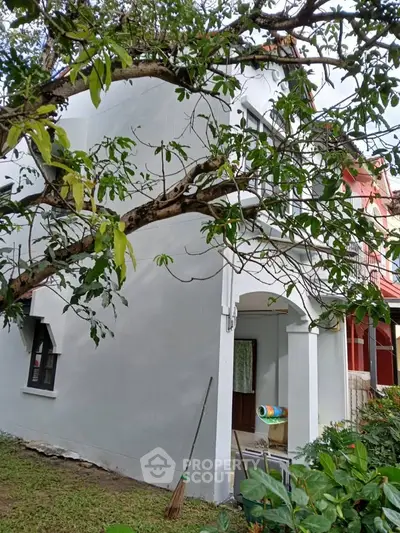 Charming two-story house with lush garden and inviting entrance