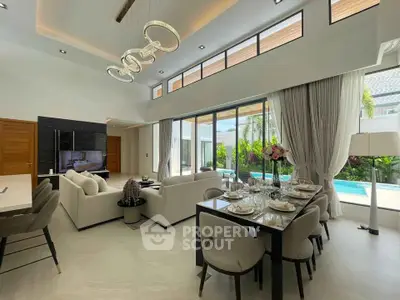 Luxurious open-plan living and dining area with pool view, modern decor, and elegant lighting.
