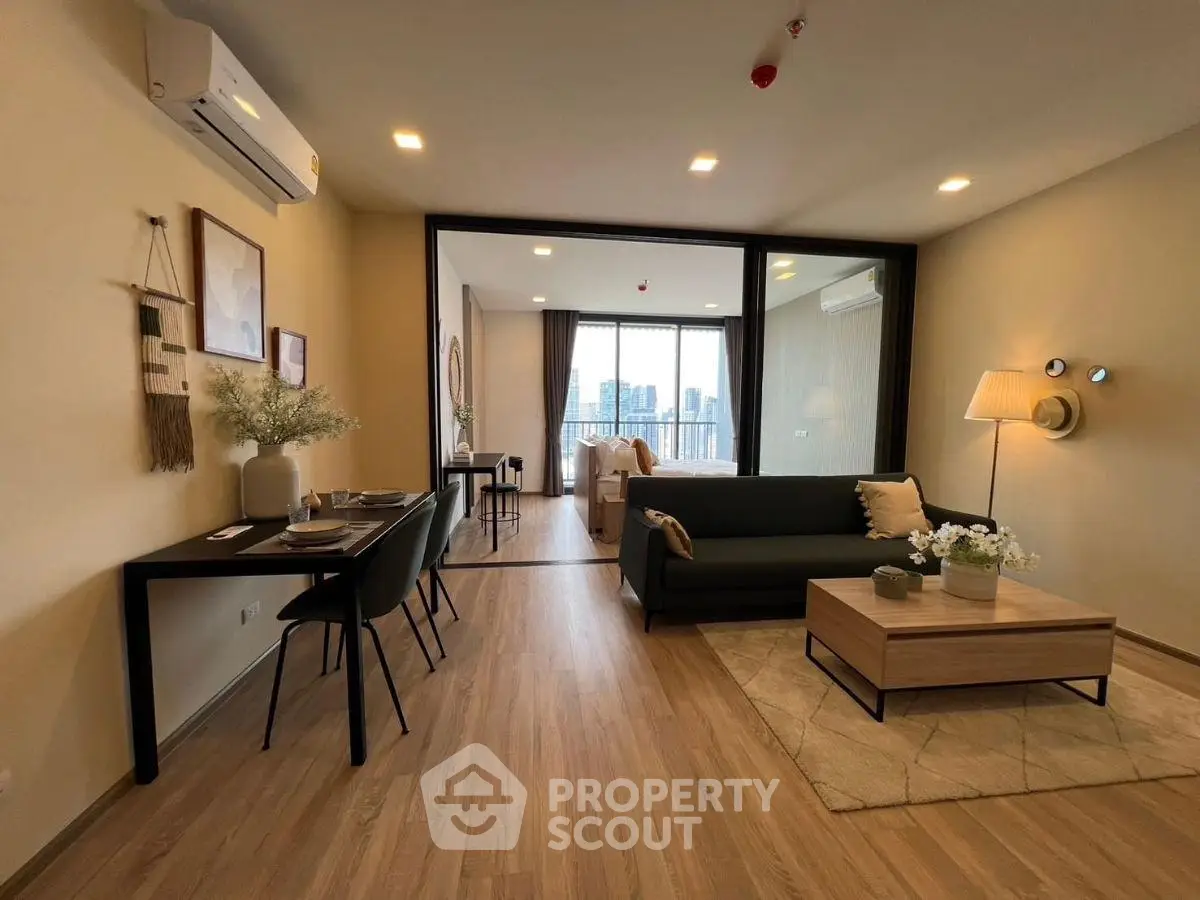 Modern living room with stylish decor and city view, featuring open layout and elegant furnishings.